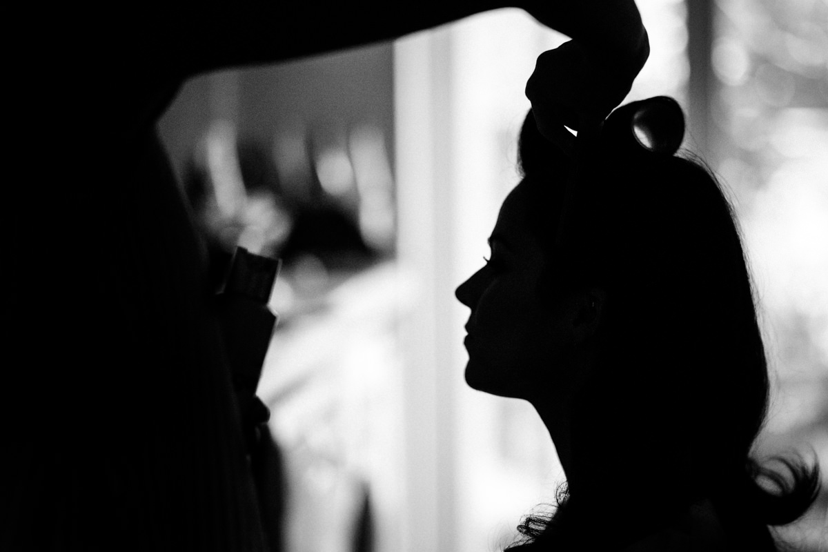 Silhouette of bride having her hair done