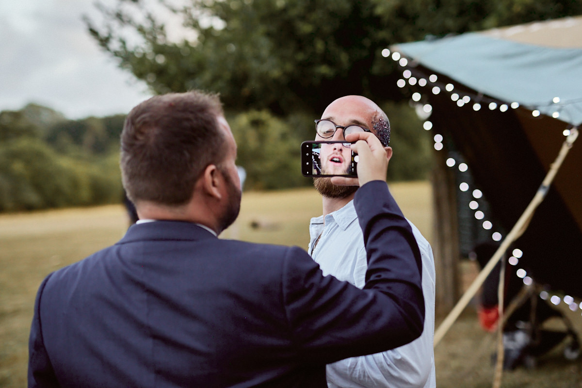Funny wedding photo of a guest having picture taken on mobile phone