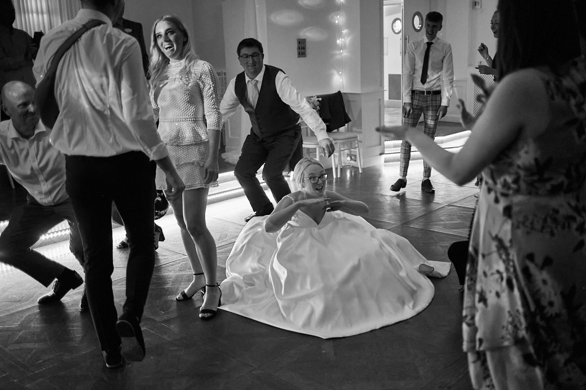 Funny wedding photo of bride dancing in her dress