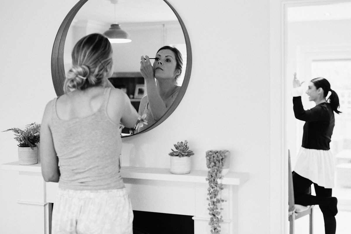 Bride applies eye make-up before wedding at Great Barn in Rolvenden Kent