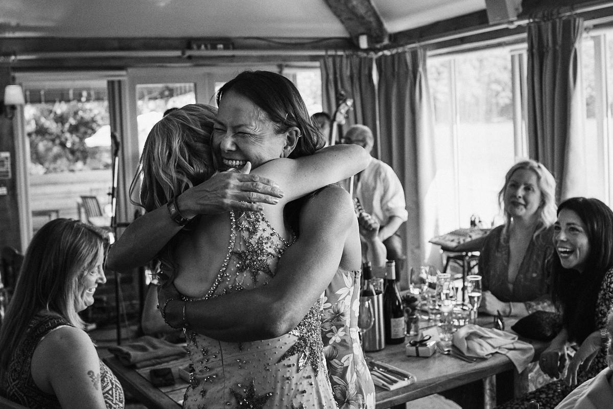 Bride hugs singer at Welldiggers arms pub wedding in Petworth, Sussex