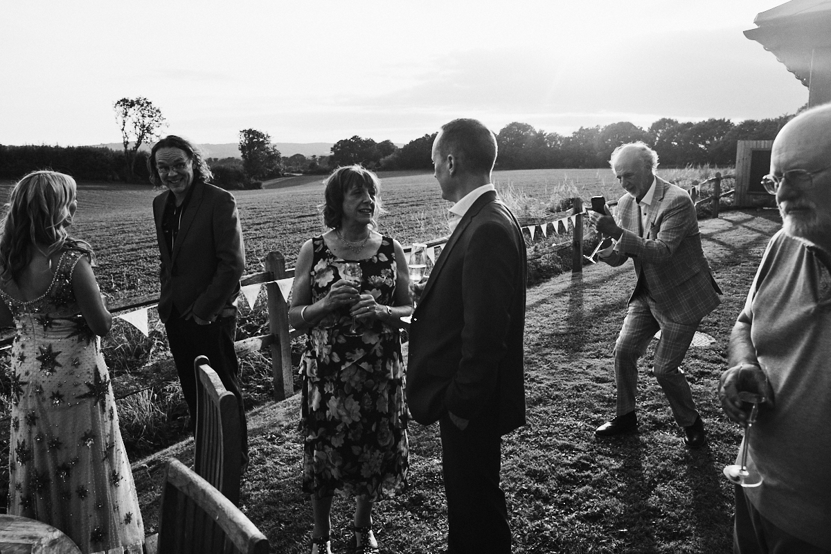 Guests takes photo on phone at Welldiggers arms pub wedding in Petworth, Sussex